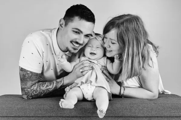 parents et leur enfant enlacés – séance photo famille naturelle en noir et blanc  – studio photo Lyon