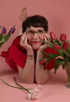 photographie d'artisane d'arrt - portrait modeliste sur fond rose entourée de fleurs - studio photo 